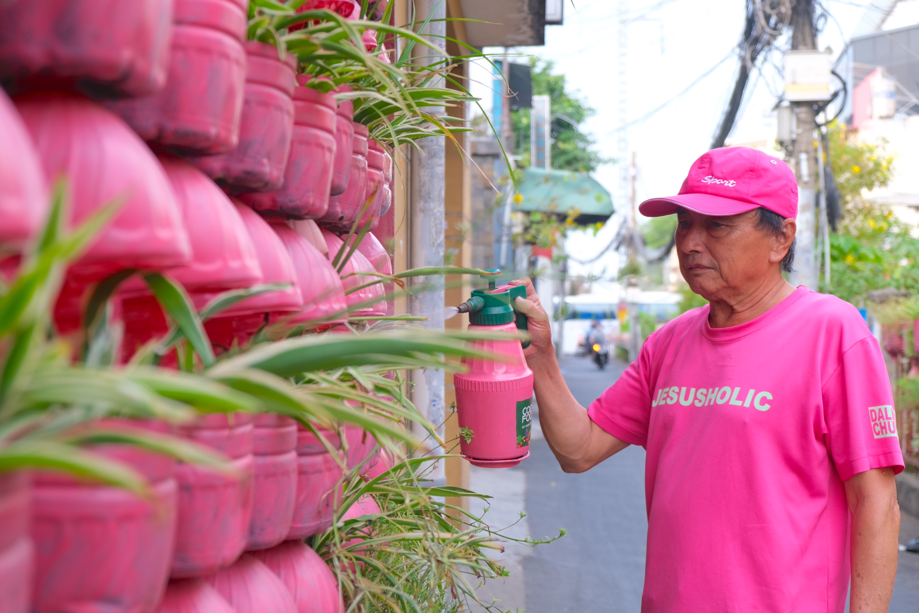Chanh waters flower pots in front of his pink house in Phu Nhuan District, Ho Chi Minh City. Photo: Ngoc Phuong / Tuoi Tre News