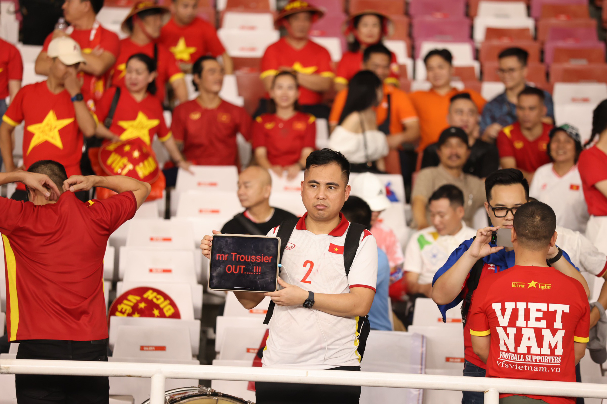 A Vietnamese supporter holds a ‘Mr. Troussier OUT…!!!’ sign after Vietnam’s 0-1 defeat to Indonesia in the second round of the 2026 FIFA World Cup Asian qualifiers at the Gelora Bung Karno Stadium in Jakarta, March 21, 2024. Photo: N.K. / Tuoi Tre