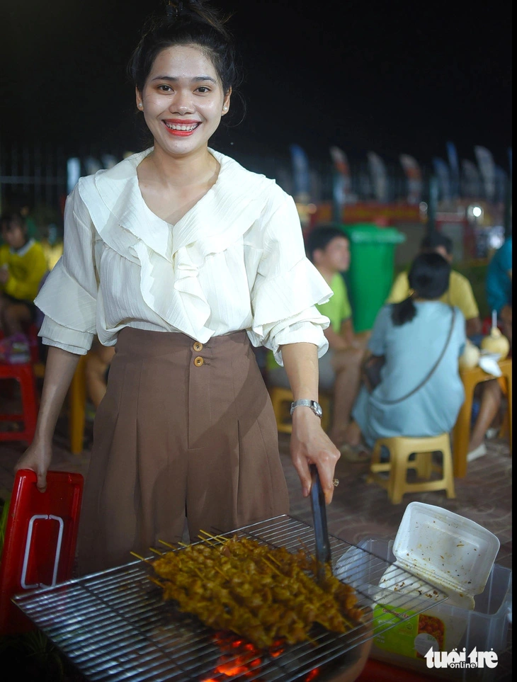 A visitor takes part in grilling meat at the culinary culture fest in Binh Dinh Province’s Quy Nhon City, south-central Vietnam, March 22, 2024. Photo: Lam Thien / Tuoi Tre