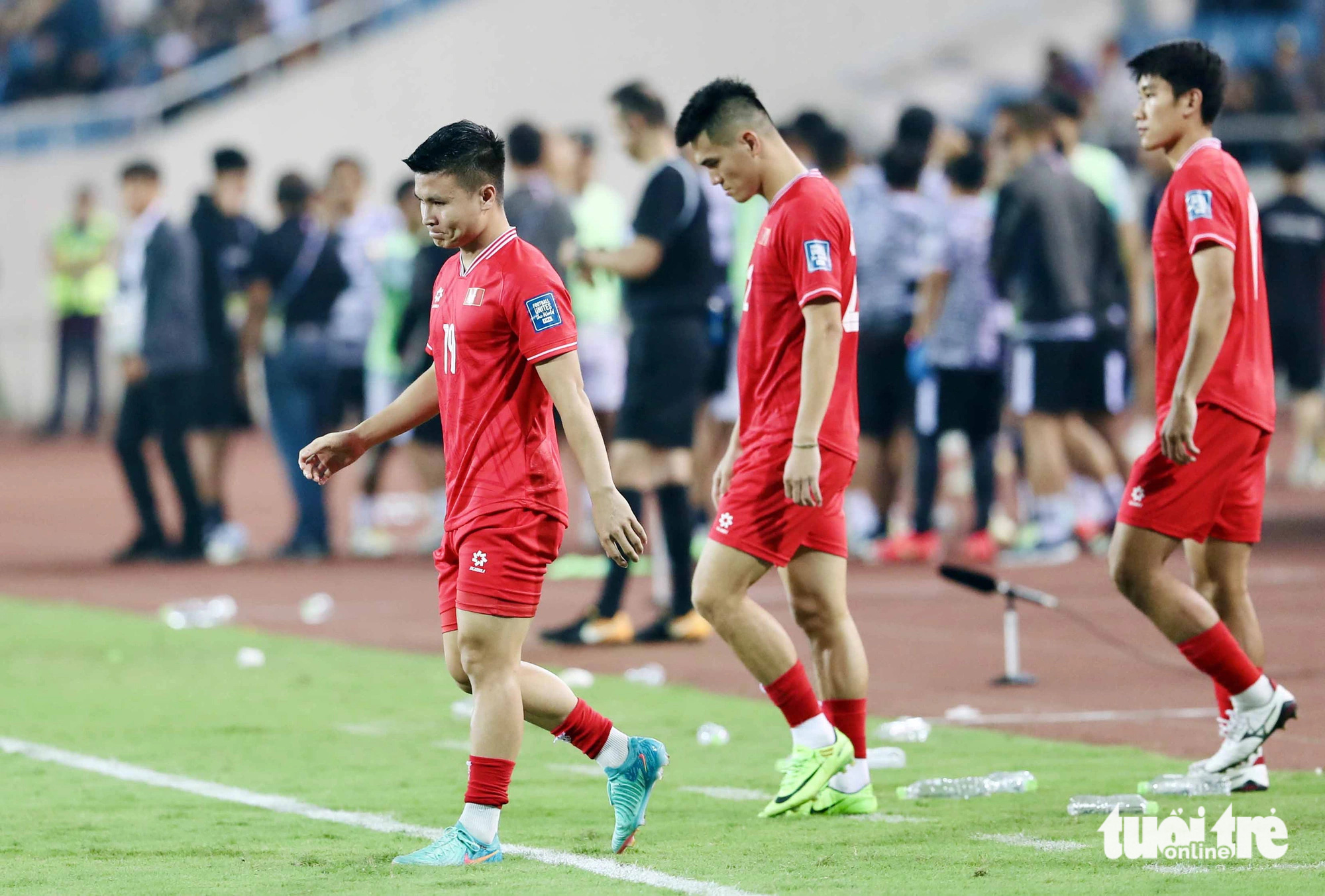 Vietnamese midfielder Nguyen Quang Hai (L) and his teammates leave the field after their 0-1 defeat to Indonesia at My Dinh National Stadium in Hanoi, March 26, 2024. Photo: Hoang Tung / Tuoi Tre