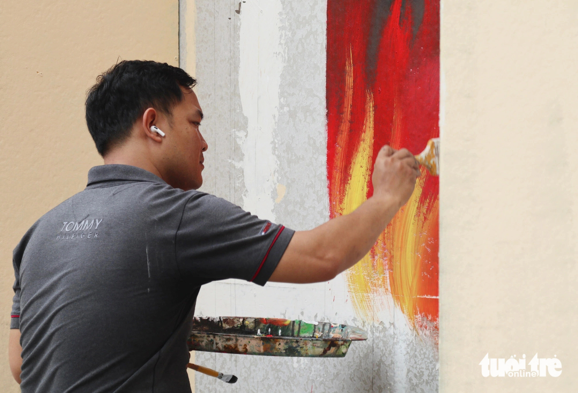 A man repaints a wall of the playground. Photo: Doan Hoa / Tuoi Tre