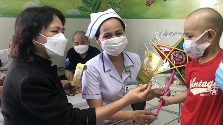 A social worker named Tra (C) connects benefactors to bring gifts to young cancer patients. Photo: Doan Nhan / Tuoi Tre