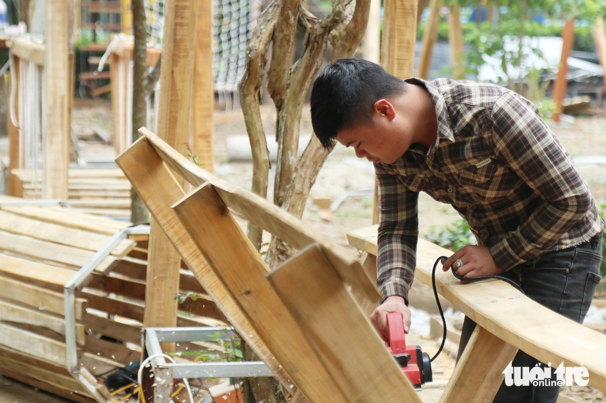 A woodworker is seen working at a new playground at the Vinh City park. Photo: Doan Hoa / Tuoi Tre