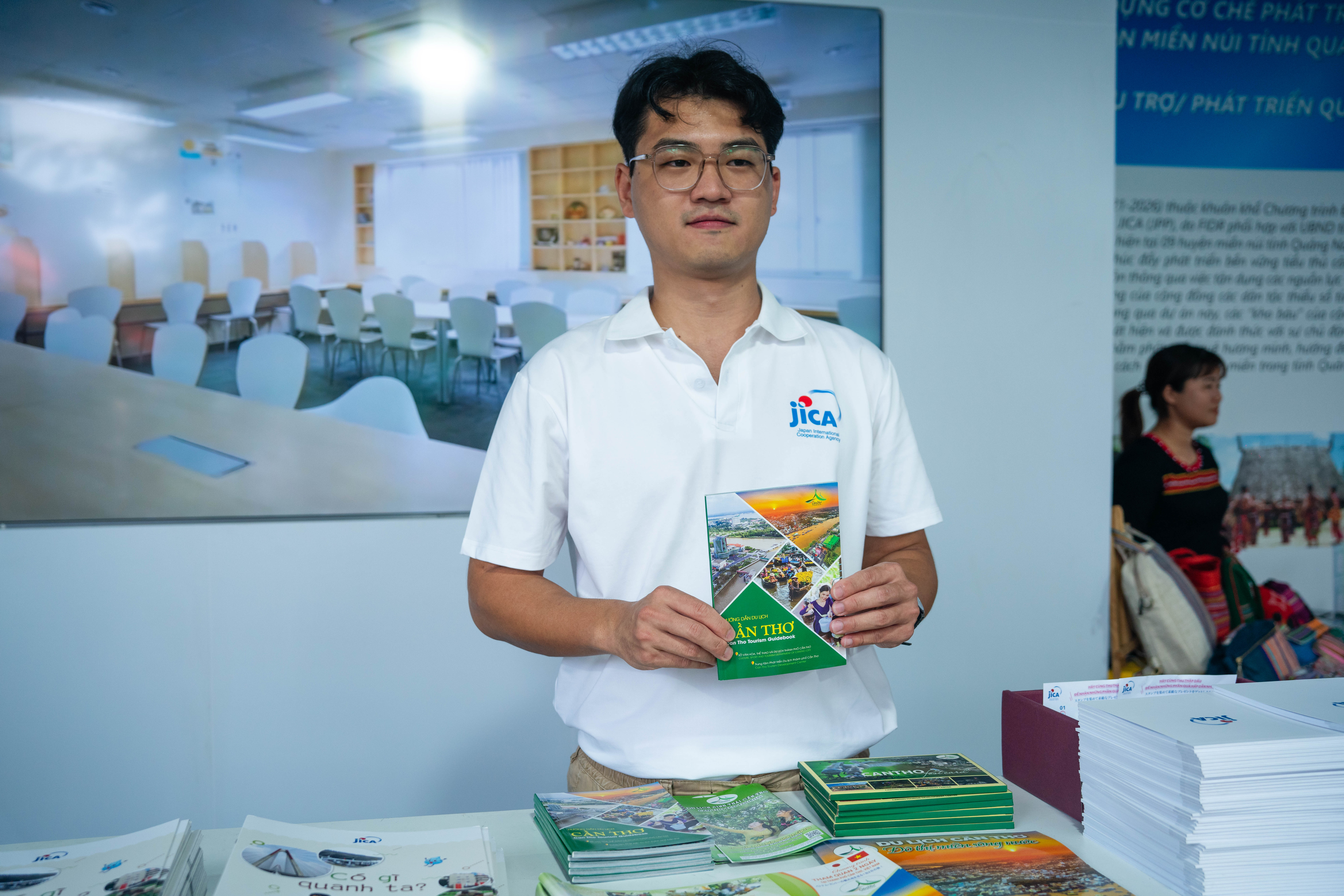 Kamiji Shota posing with Can Tho tourism promoting documents while introducing his work in the festival. Photo: Ngoc Duc / Tuoi Tre