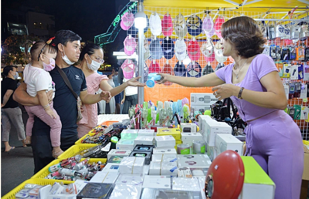 Residents entertain and shop a night quarter near the Quang Trung flag tower in District 10, Ho Chi Minh City. Photo: Tu Trung / Tuoi Tre