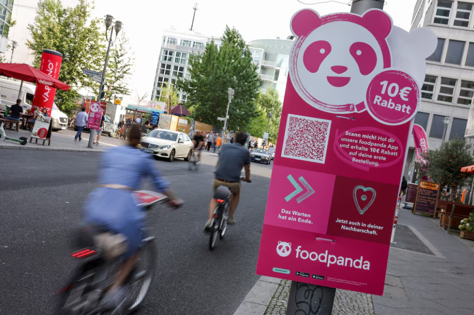 Cyclists drive past an advertisement promoting the grocery delivery company 'foodpanda', in Berlin, Germany, August 13, 2021. Photo: Reuters