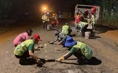 Young people cover potholes under streetlights in Gia Lai Province. Photo: Tuan Thanh