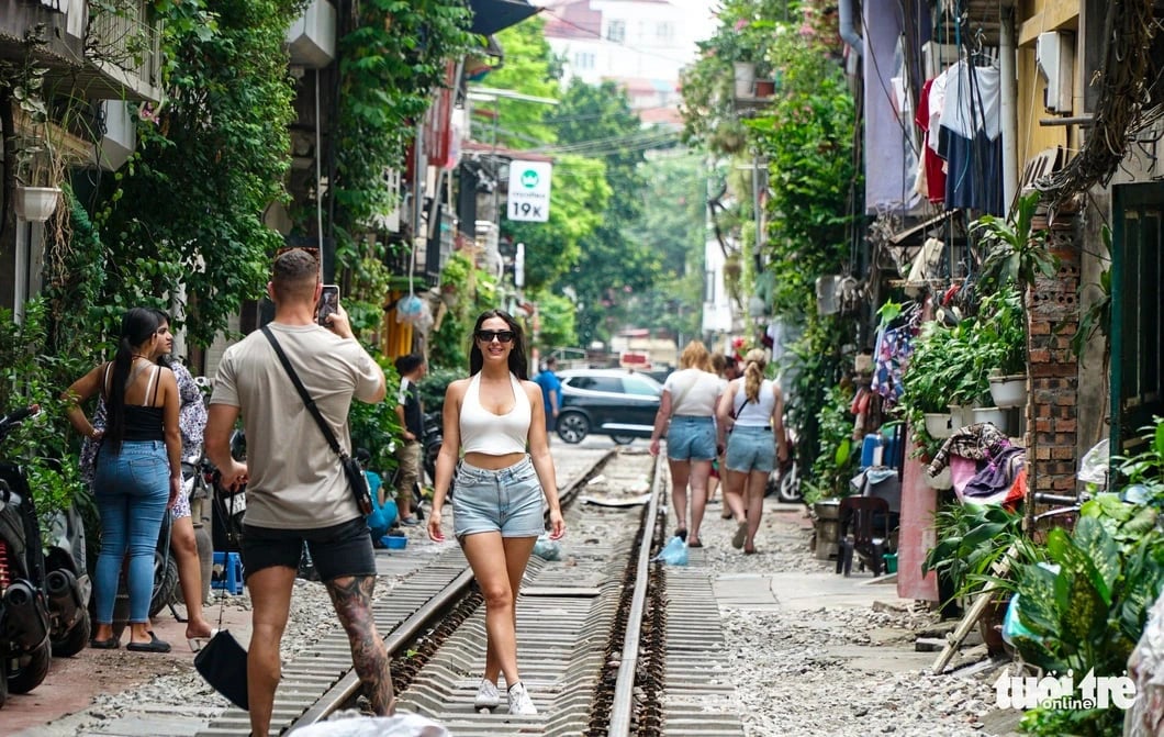 Foreign tourists take photos on the trackside café street in Ba Dinh District, Hanoi, Vietnam in this illustration photo. Photo: Nguyen Hien / Tuoi Tre