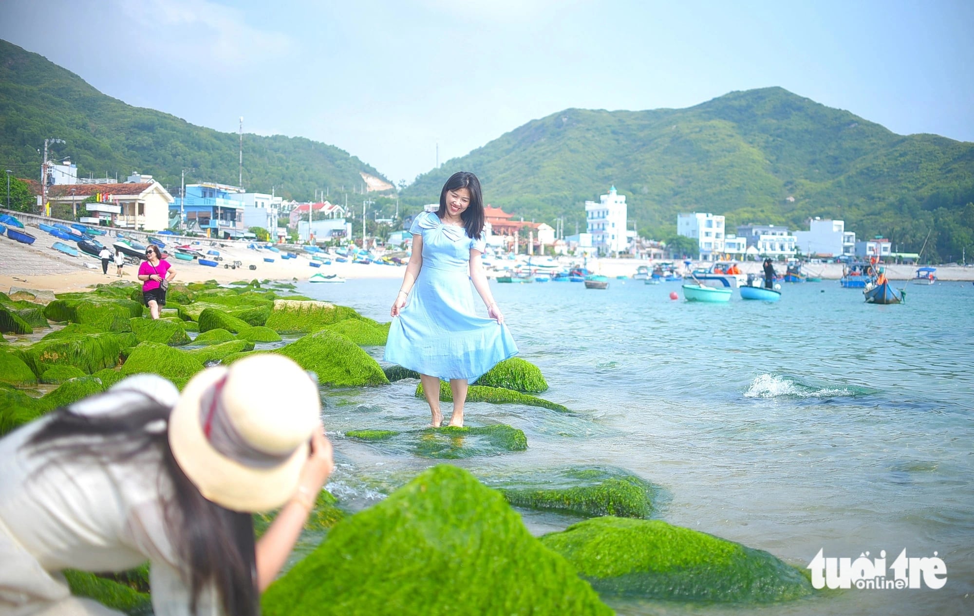 A tourist poses for a photo while visiting a moss-covered reef at a beach in Nhon Hai Commune, Quy Nhon City, Binh Dinh Province, central Vietnam in this illustration photo. Photo: Lam Thien / Tuoi Tre