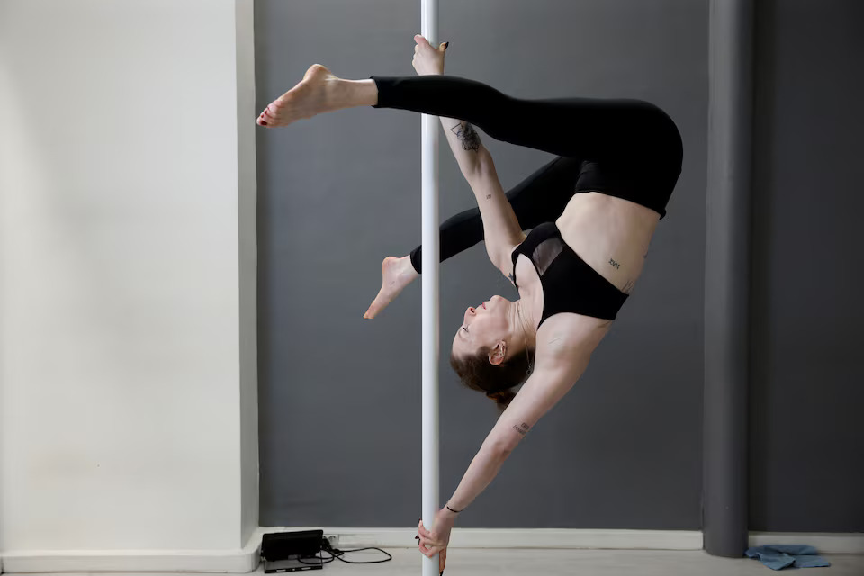Anna Gorynsztejn, co-owner of Wild Pole Studio, shows a figure on a pole at the pole dancing studio Wild Pole in Paris, France, March 26, 2024. Photo: Reuters