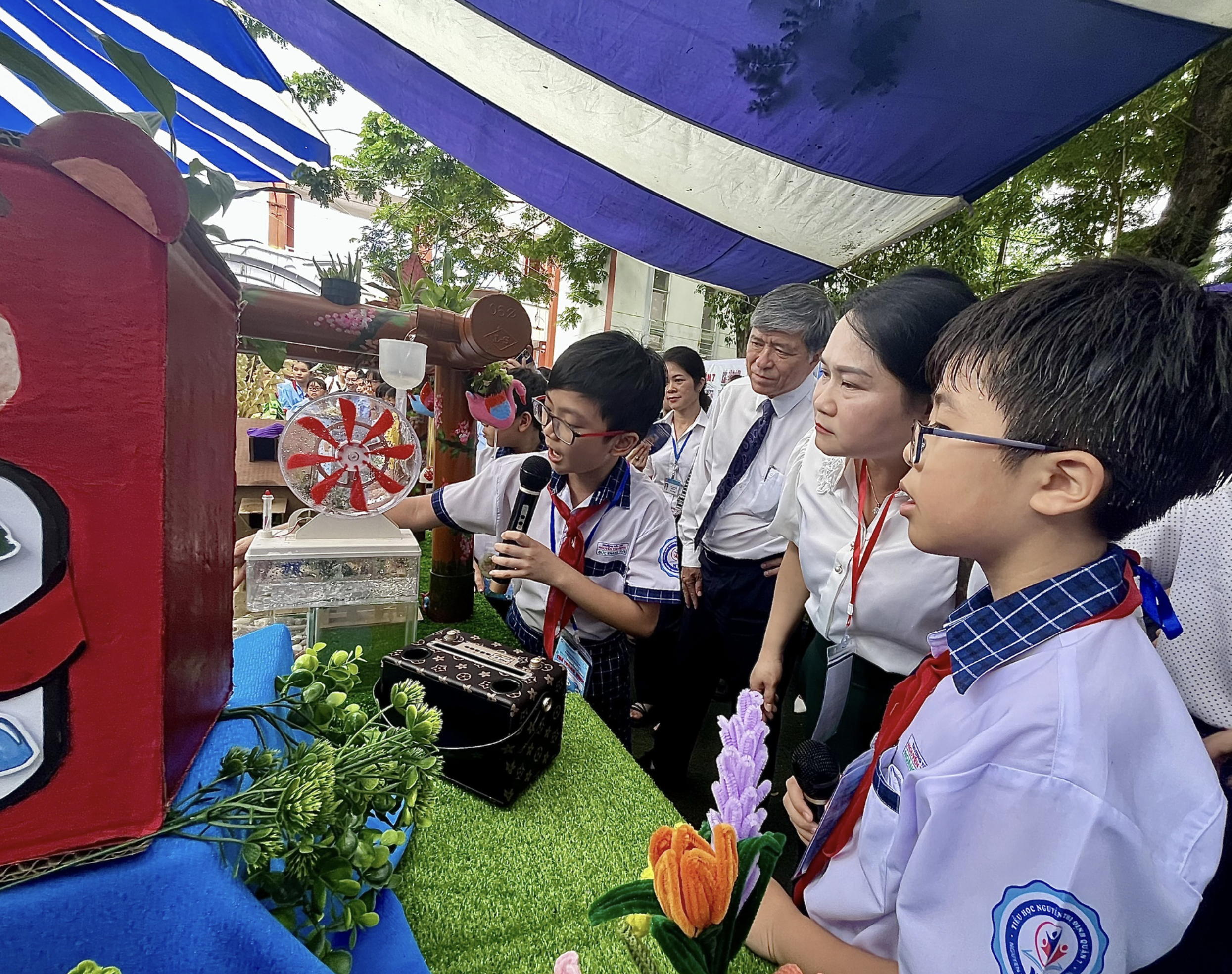 Pham Ngo Duc Khang is pictured holding a mic to introduce a smart garden model on the STEM Day in Ho Chi Minh City on April 5, 2024. Photo: My Dung / Tuoi Tre