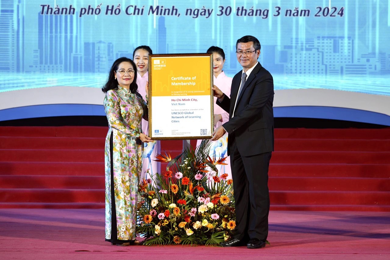 Nguyen Van Phuc, Deputy Minister of Education and Training, and Nguyen Thi Le, Deputy Secretary of the Ho Chi Minh City Party Committee, proudly display the certificate recognizing HCMC as a global learning city. Photo by Huu Hanh / Tuoi Tre.