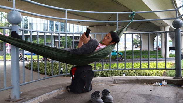 Vo Minh Cuong, a 38-year-old worker from Thu Duc City, under Ho Chi Minh City, lies on a hammock under Ba Son Bridge in District 1, Ho Chi Minh City. Photo: An Vi / Tuoi Tre