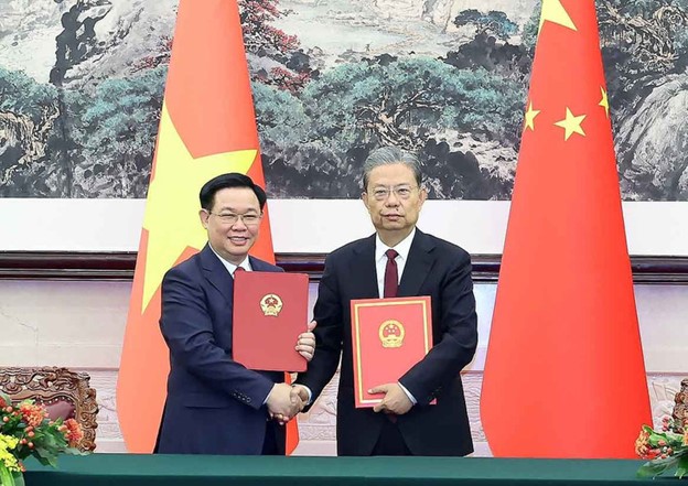 Vietnam’s National Assembly Chairman Vuong Dinh Hue (L) and Chairman of the Standing Committee of the National People's Congress of China Zhao Leji exchange a cooperation agreement between the two nations’ legislatures. Photo: VNA