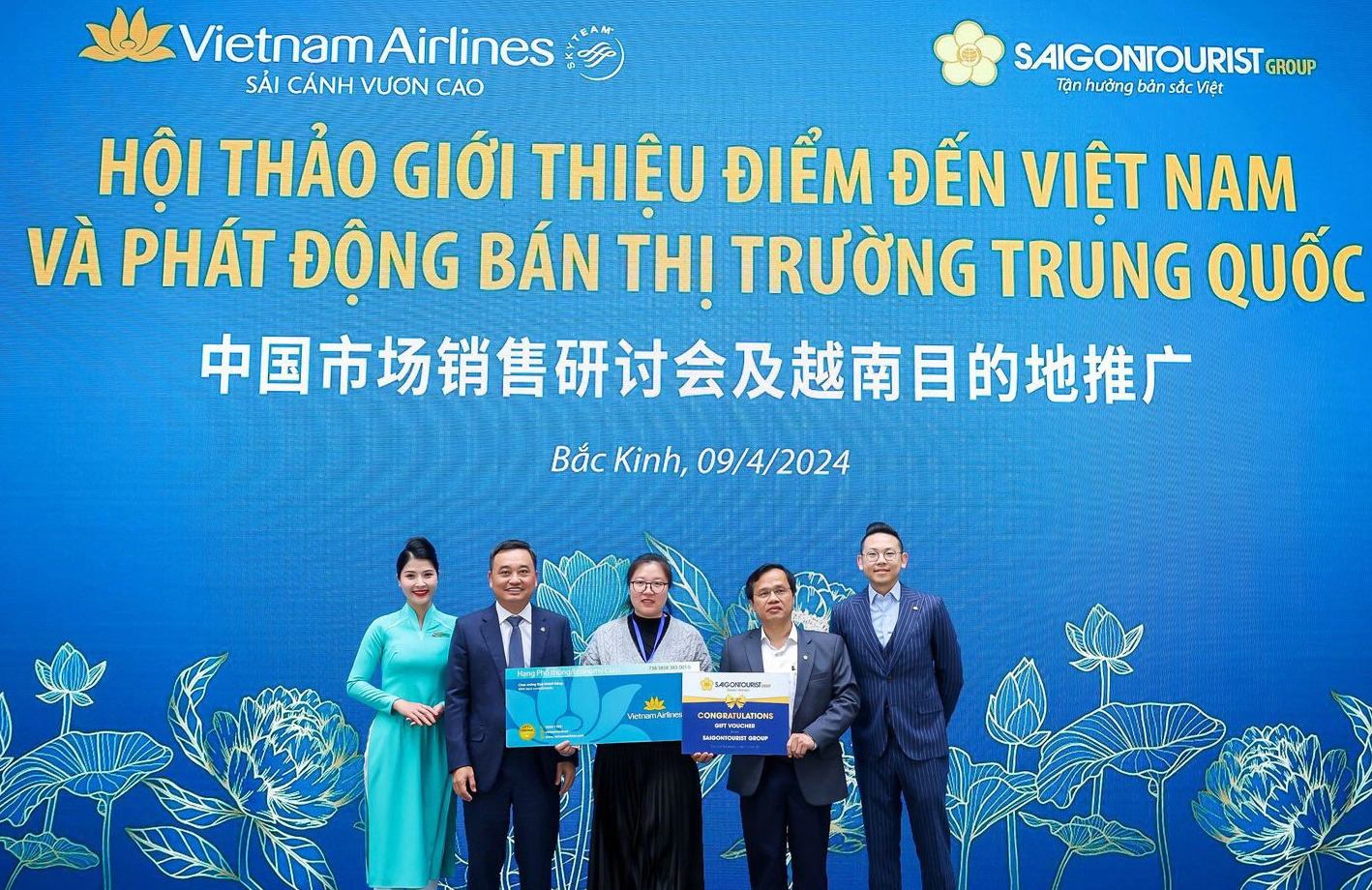 A guest receives lucky gifts which allow her to use Vietnam Airlines and Saigontourist Group services in a program promoting Vietnamese destinations in Beijing, China, April 9, 2024. Photo: Supplied