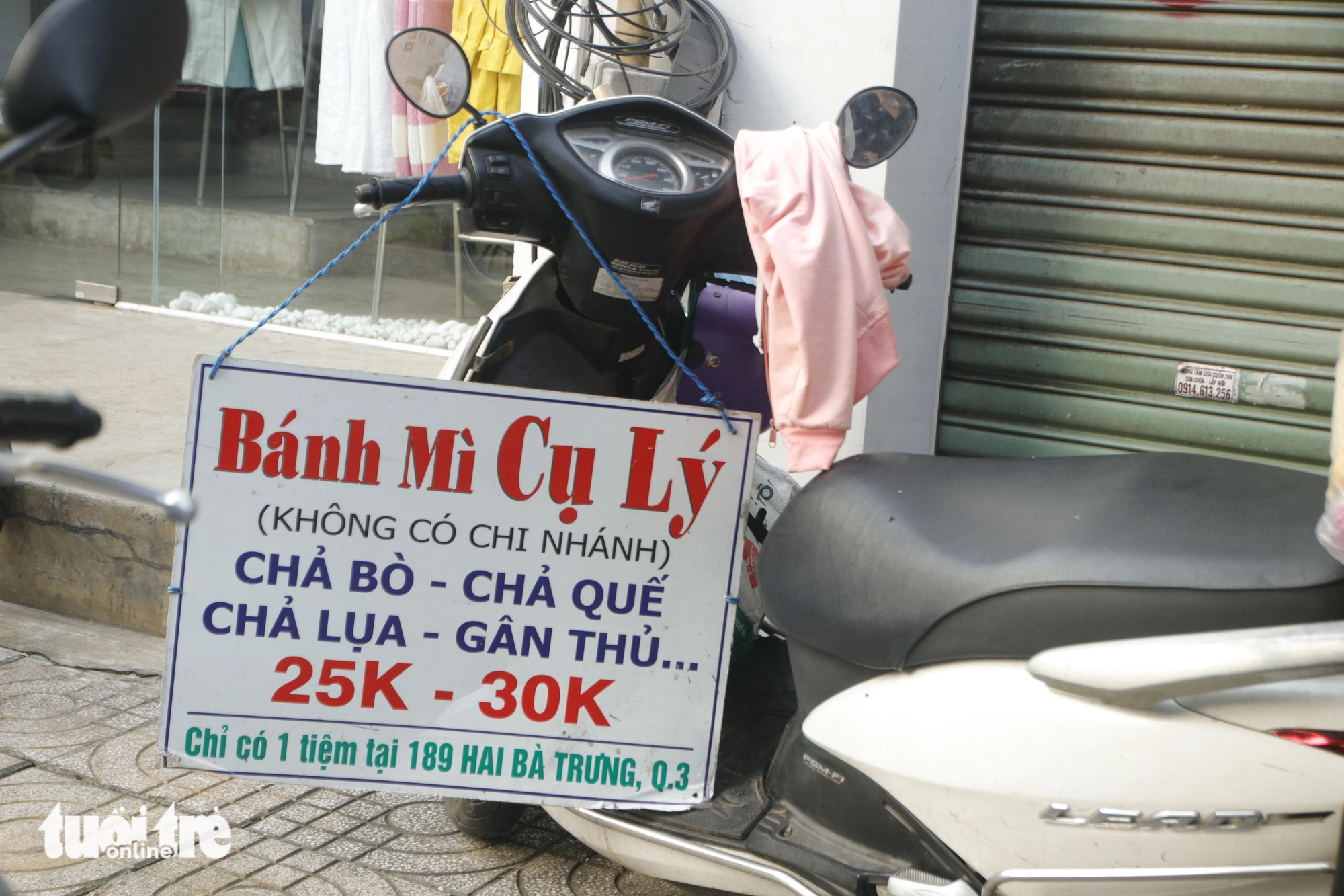 A modest sign for Mr. Ly’s 'banh mi' stall hangs on a motorbike. Photo: Ho Lam / Tuoi Tre