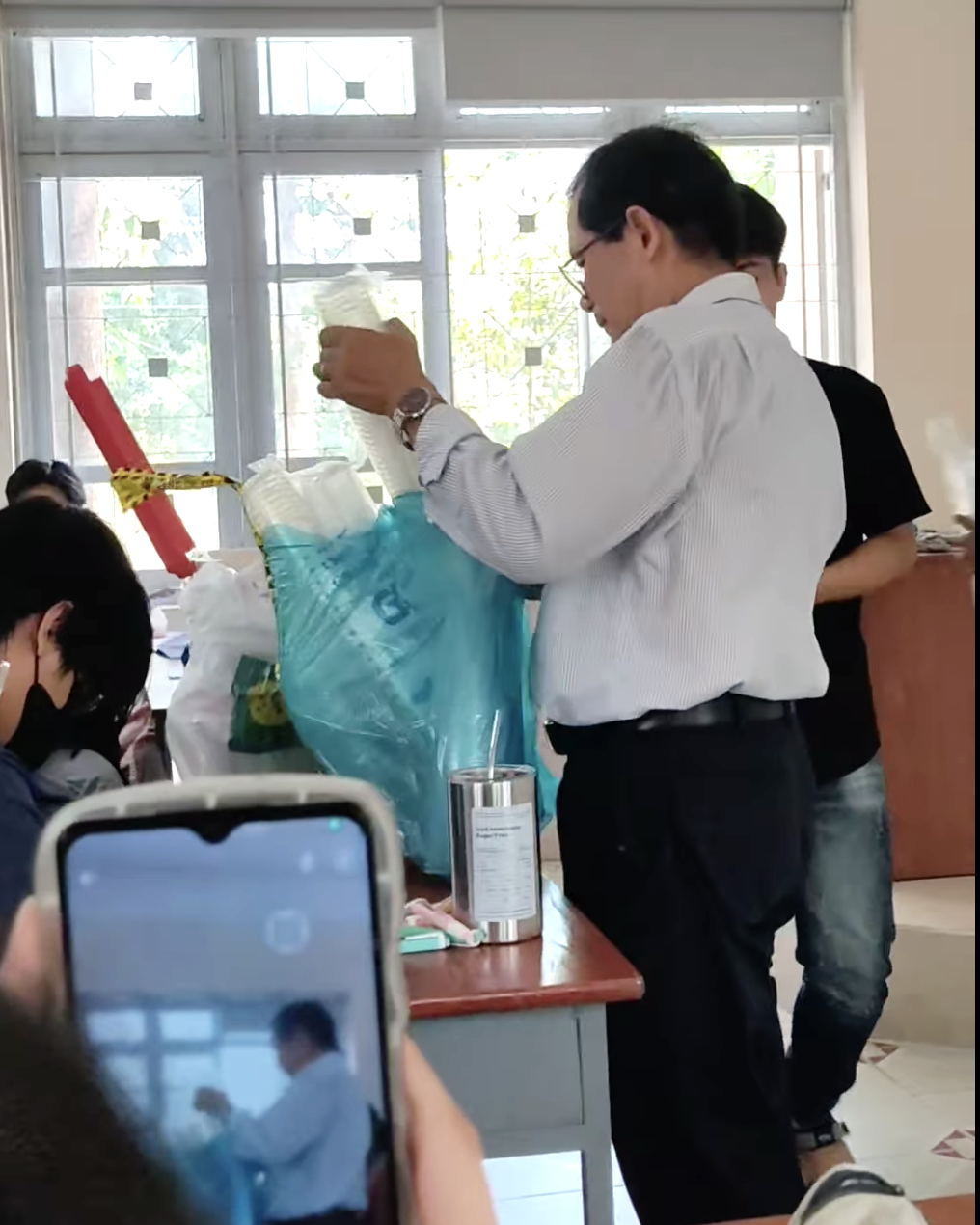 Dr. Le Quang Thong from the economics faculty at Ho Chi Minh City University of Agriculture and Forestry distributes iced soft drinks to his students, April 11, 2024. Photo: Facebook