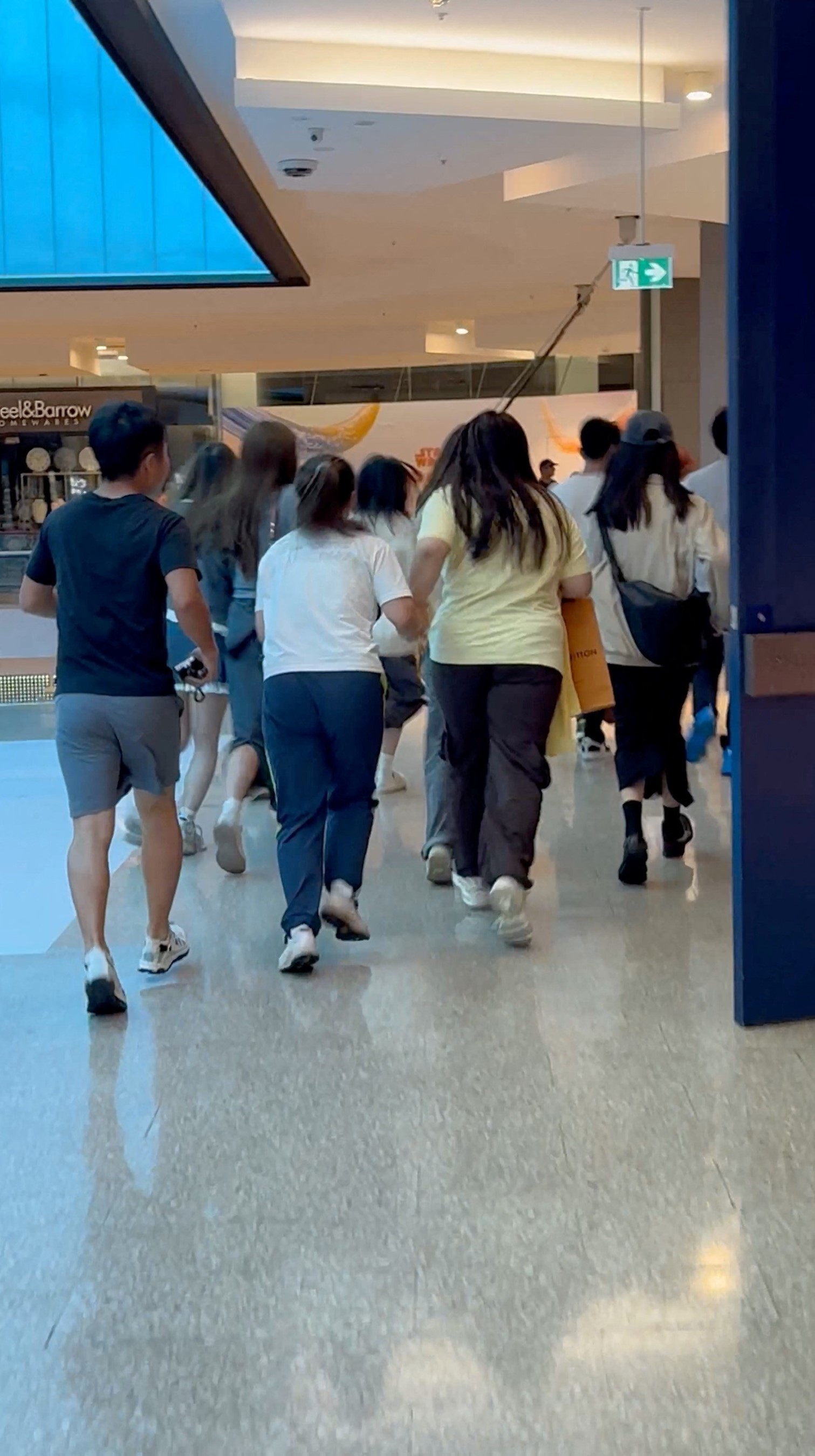 People run inside the Westfield Bondi Junction shopping center, as they evacuate the scene of an incident, in which an attacker was shot after fatally wounding several people with a knife, in Sydney, Australia April 13, 2024 in this screengrab obtained from a social media video.
