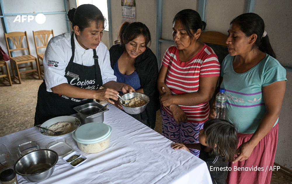 Adeli Yanos (L), president of 'Virgen del Rosario' soup kitchen, trains a group of women to prepare a dish using the peels, leaves, and stems of vegetables and fruits at the soup kitchen in Lurin, in southern Lima, on April 11, 2024. Photo: AFP