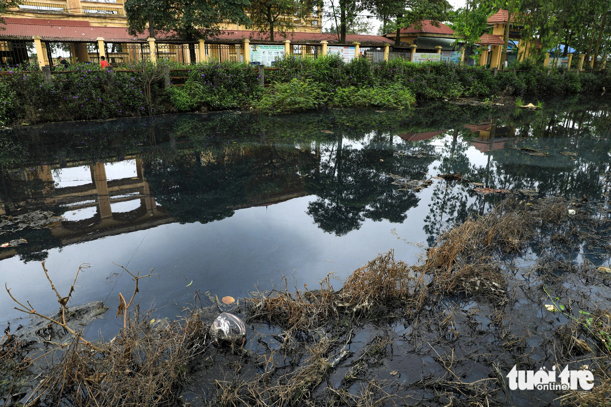 The contaminated channel runs along a local middle school and a medical center in My Hao Town, Hung Yen Province, northern Vietnam. Photo: Tuoi Tre