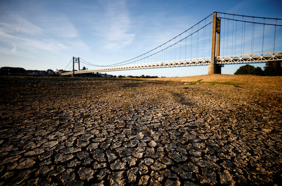 Cracked and dry earth is seen in the wide riverbed of the Loire River near the Anjou-Bretagne bridge as a heatwave hits Europe, in Ancenis-Saint-Gereon, France, June 13, 2022. Photo: Reuters