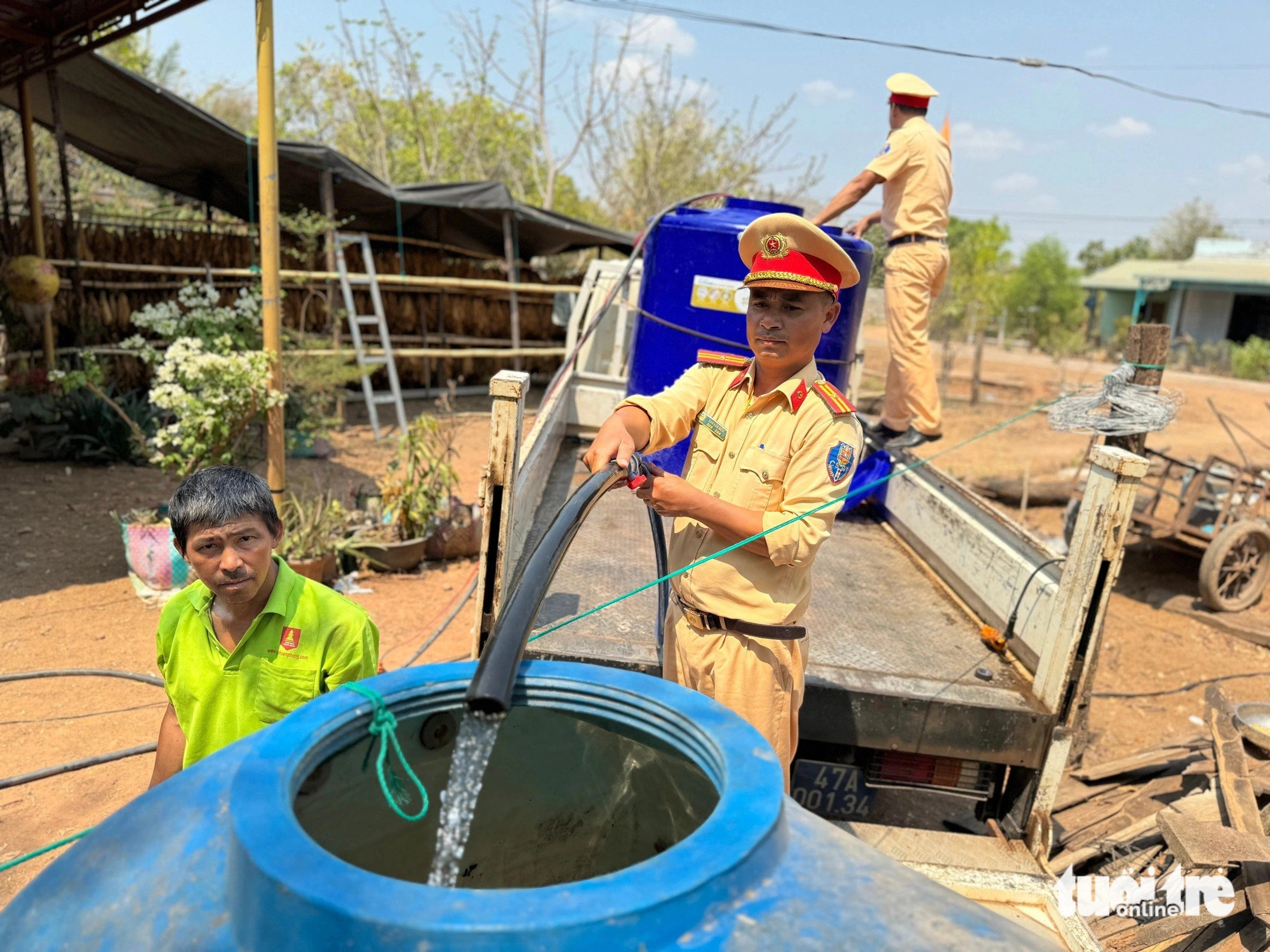 Traffic police officers distribute fresh water to deprived areas in Ea Sup District, Dak Lak Province, Vietnam’s Central Highlands. Photo: Van Dan / Tuoi Tre