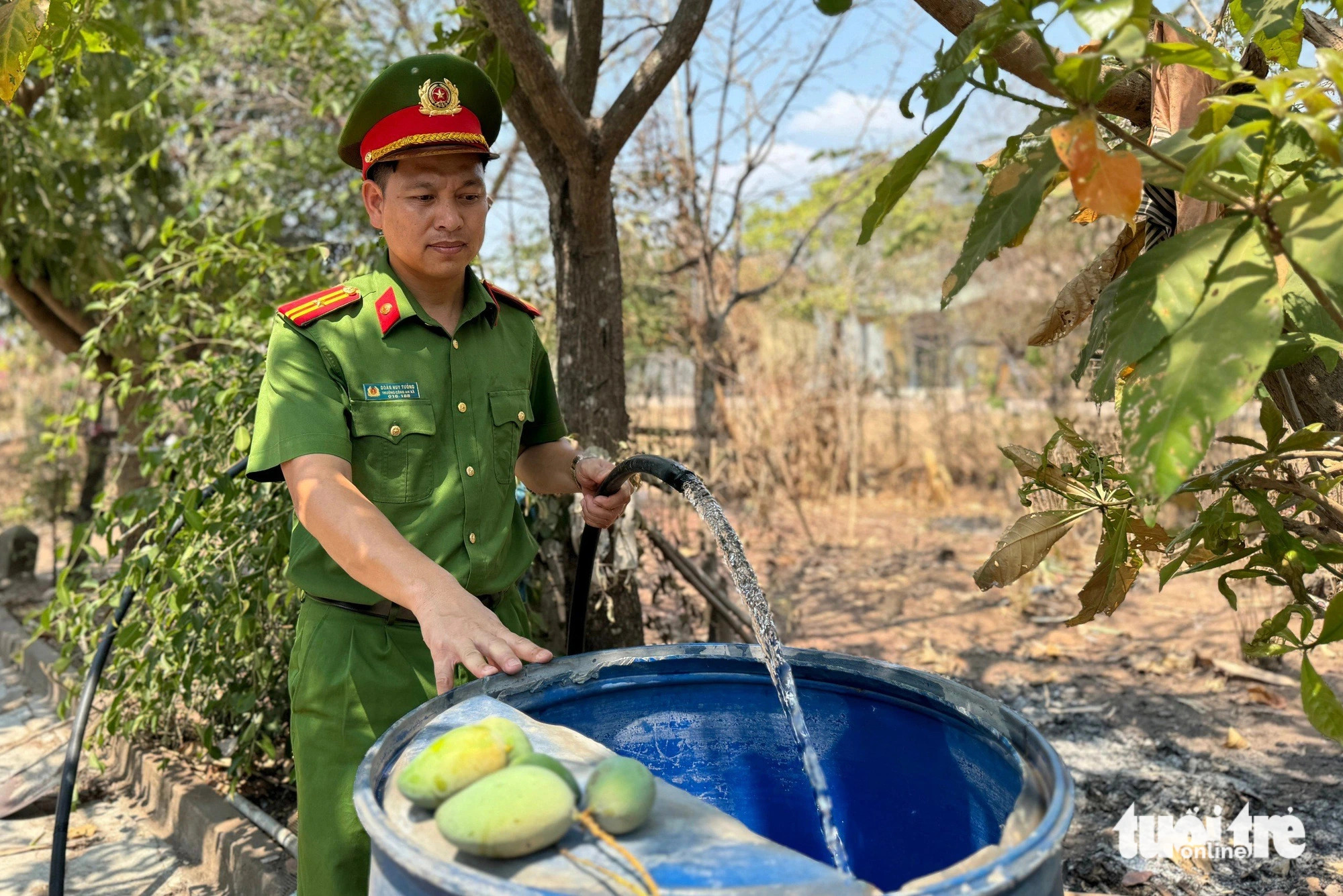 Major Doan Huy Tuong, head of the police agency in Ea R’Ve Commune, Ea Sup District, Dak Lak Province, Vietnam’s Central Highlands joins a task force to provide fresh water for local residents. Photo: Trung Tan / Tuoi Tre