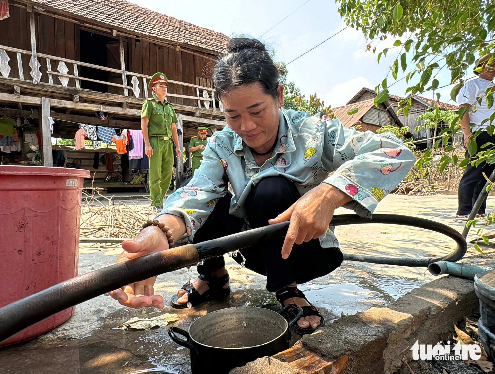 Vy Thi Mun, a 55-year-old resident in Ea R’Ve Commune, Ea Sup District, Dak Lak Province, Vietnam’s Central Highlands gets fresh water offered by the forces. Photo: Trung Tan / Tuoi Tre