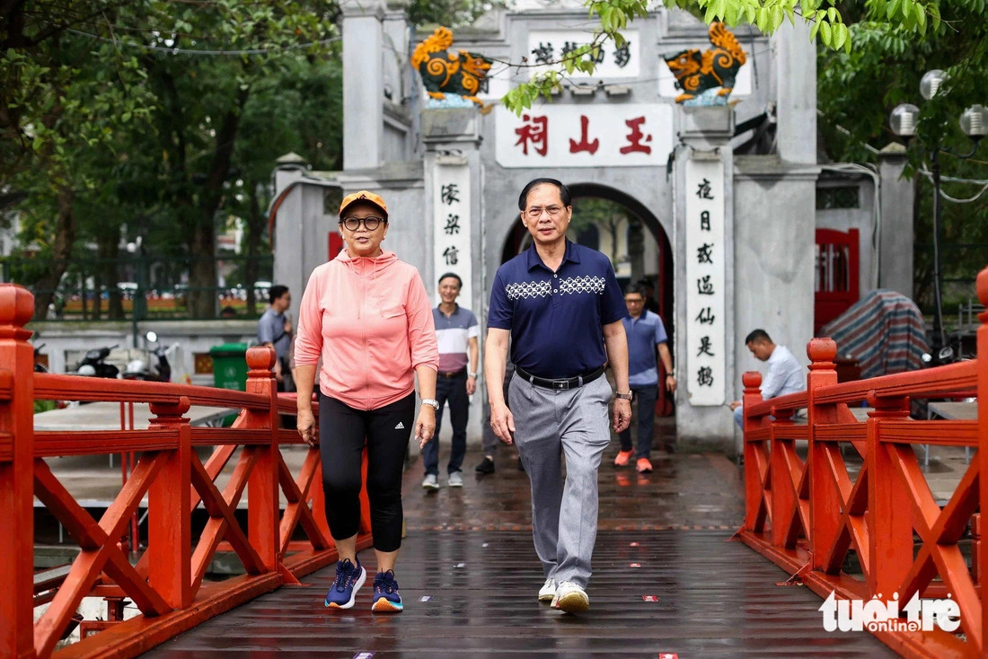 The two foreign ministers of Vietnam and Indonesia, Bui Thanh Son and Retno Marsudi, cross the The Huc Bridge in Hanoi during their walk on April 24, 2024. Photo: Nguyen Khanh / Tuoi Tre