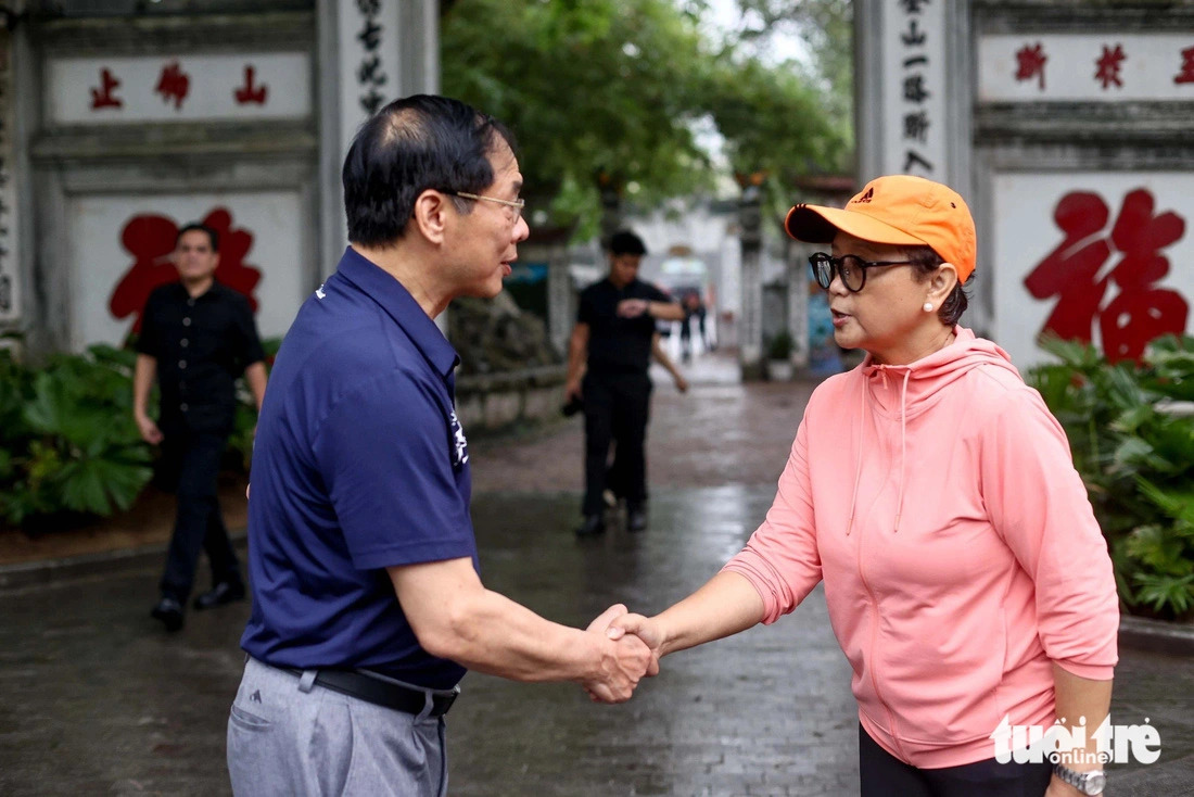 The Vietnamese Minister of Foreign Affairs shakes hands with his Indonesian counterpart Retno Marsudi when they end their walk around the Hoan Kiem Lake in Hanoi on April 24, 2024. Photo: Nguyen Khanh / Tuoi Tre