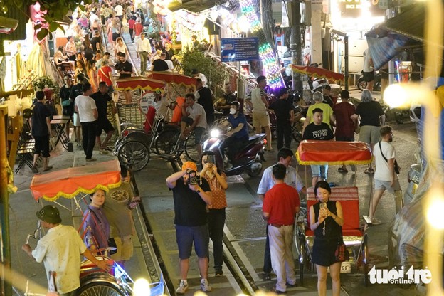 People throng the trackside café street despite signs banning gatherings there. Photo: T.T.D. / Tuoi Tre