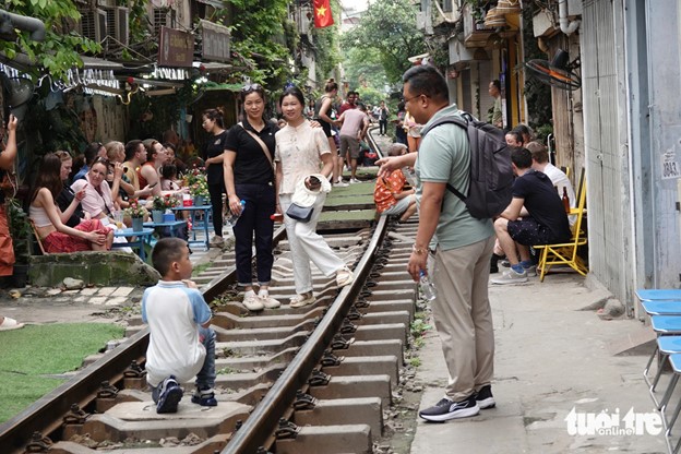 Tourists pose for photos on a track section at 224 Le Duan Street in Hanoi. Photo: T.T.D. / Tuoi Tre
