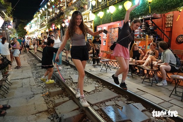 Two foreign women keep balance on the track. Photo: T.T.D. / Tuoi Tre