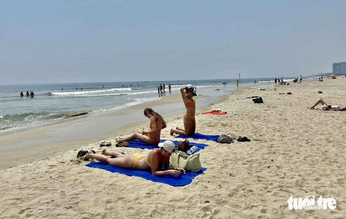A group of travelers from Nordic countries lie on the sand for sunbathing on the My Khe Beach in Da Nang City, central Vietnam on April 27, 2024. Photo: Truong Trung / Tuoi Tre