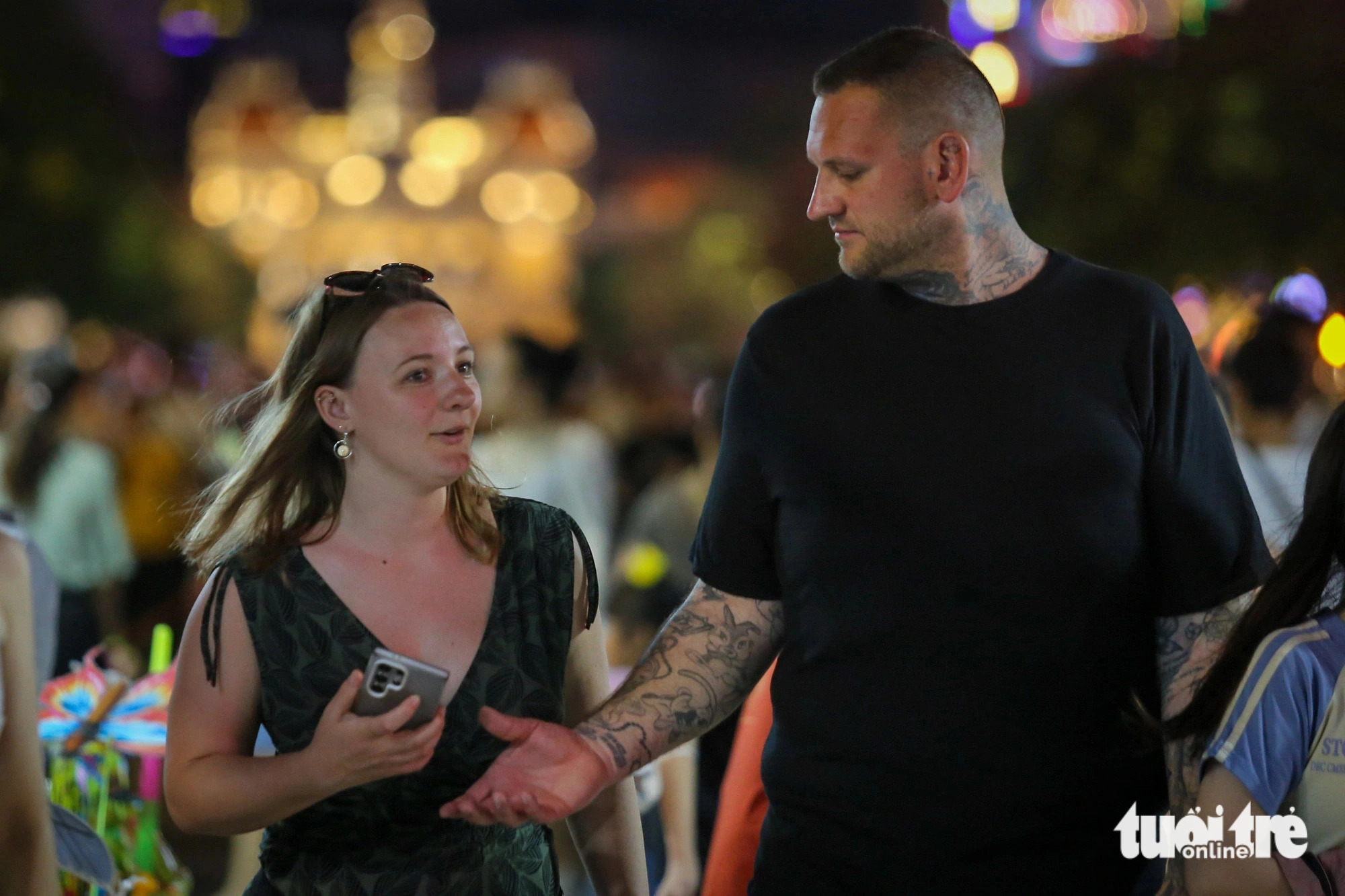 Two Russian visitors are seen strolling along Nguyen Hue pedestrian street in District 1, Ho Chi Minh City where crowds of people gather to watch a firework show. Photo: Phuong Quyen / Tuoi Tre