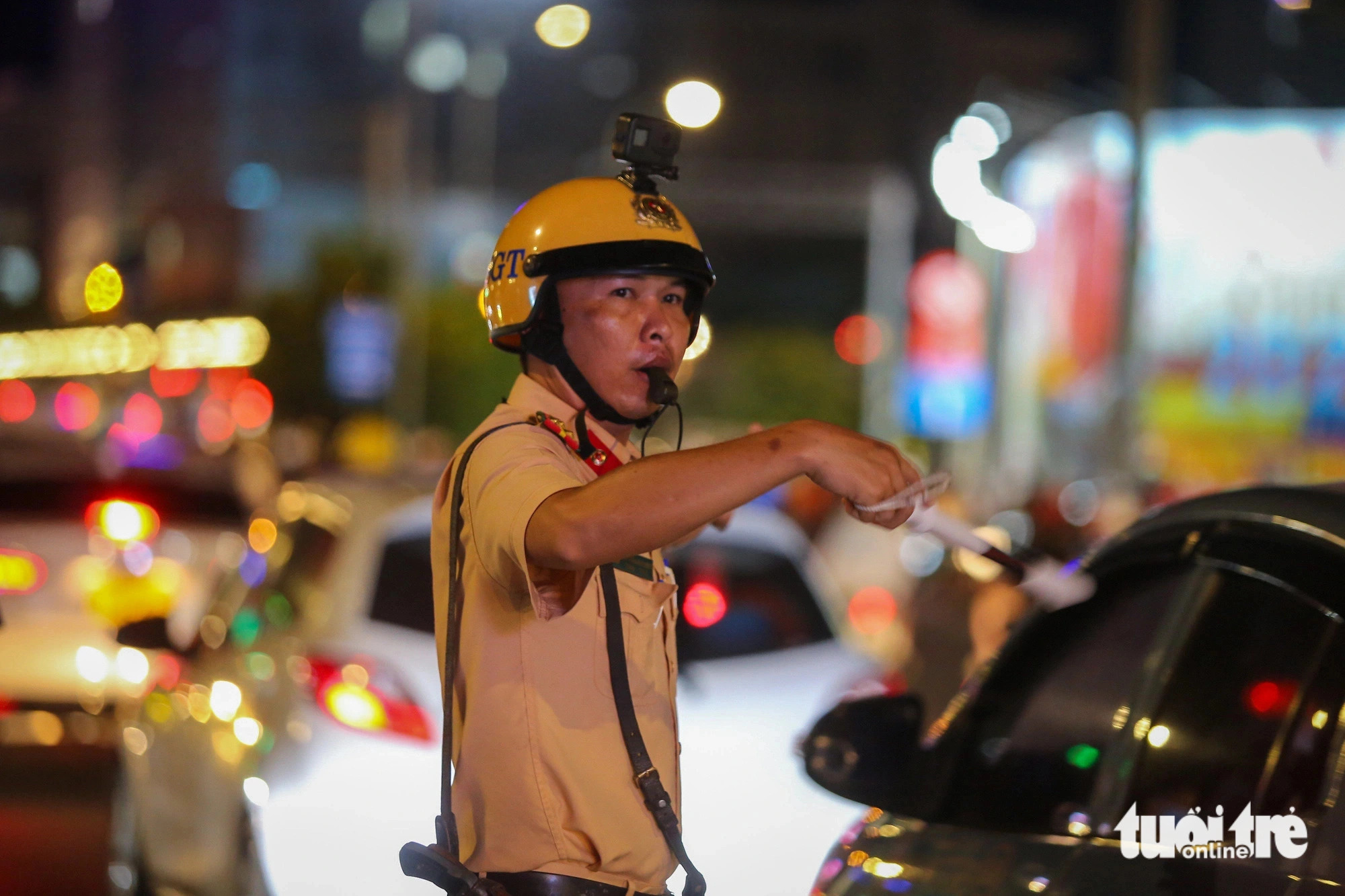 A traffic police officer is seen directing the traffic flow to serve the display of fireworks in downtown Ho Chi Minh City, April 30, 2024. Photo: Phuong Quyen / Tuoi Tre