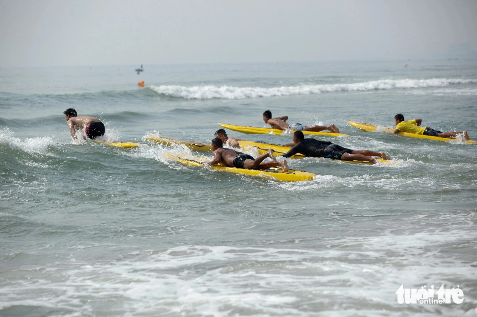 Contestants swim to rescue a drowning individual in a simulated scenario. Photo: Doan Nhan / Tuoi Tre