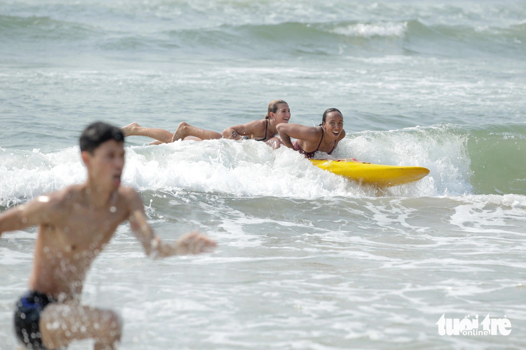 Two Australian female lifeguards bring a drowning victim back to shore. Photo: Doan Nhan / Tuoi Tre