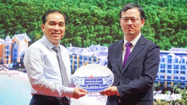 Huynh Quang Hung (L), chairman of the administration in Phu Quoc City, Kien Giang Province, gives a souvenir to a representative of the Chinese Consulate General in Ho Chi Minh City. Photo: Chi Cong / Tuoi Tre