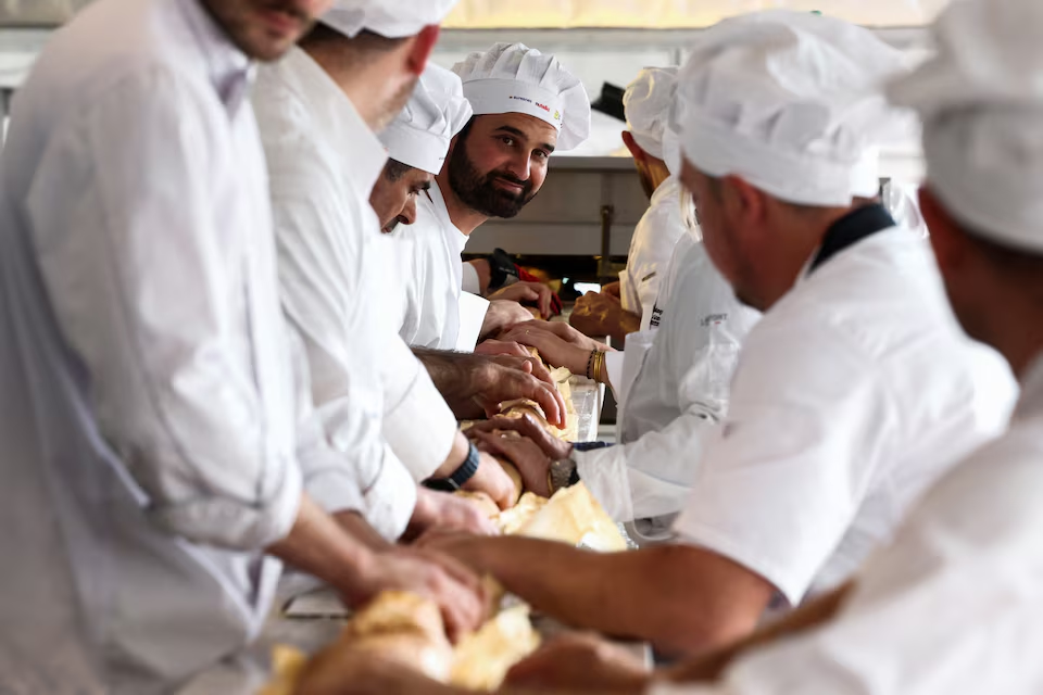 French bakers stand near a large rotating oven in an attempt to beat the world record for the longest baguette during the Suresnes Baguette Show in Suresnes near Paris, France, May 5, 2024. Photo: Reuters