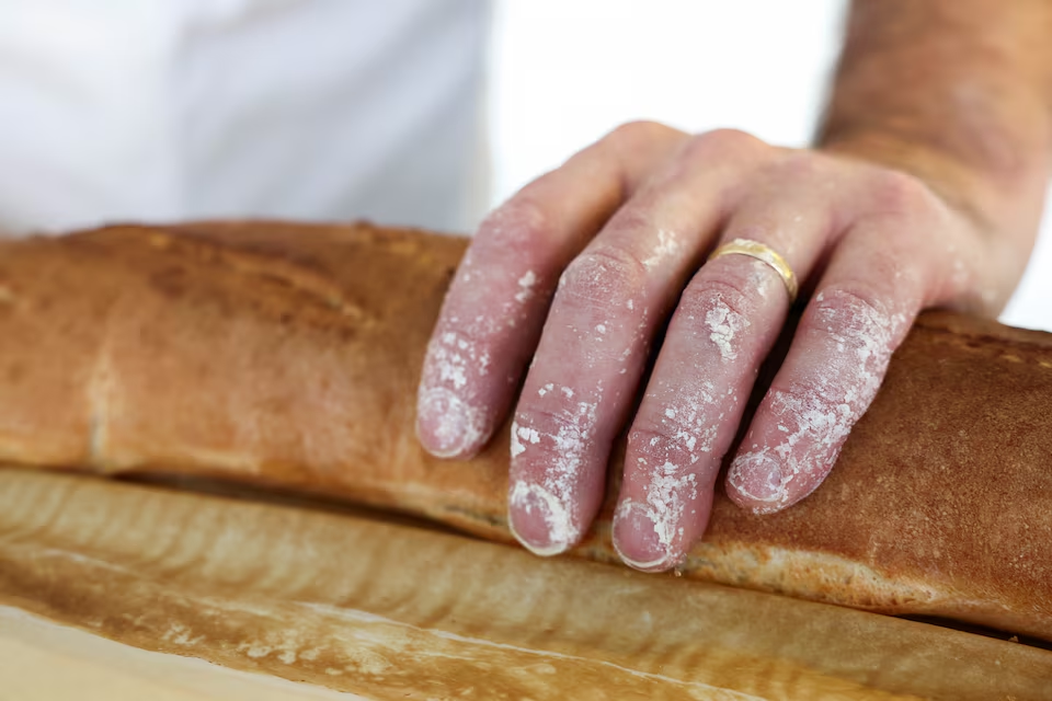 A French baker touches the baguette as he stands near a large rotating oven in an attempt to beat the world record for the longest baguette during the Suresnes Baguette Show in Suresnes near Paris, France, May 5, 2024. Photo: Reuters