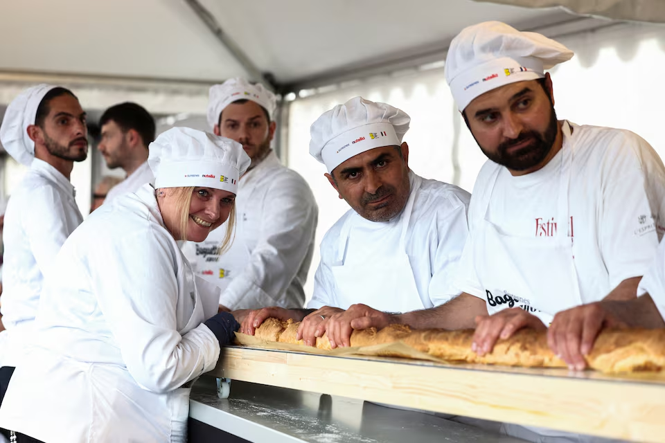 French bakers stand near a large rotating oven in an attempt to beat the world record for the longest baguette during the Suresnes Baguette Show in Suresnes near Paris, France, May 5, 2024. Photo: Reuters