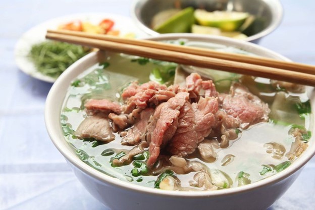 Rough Guides suggests squeezing a lime and adding a dash of chili flakes to a bowl of 'pho'. Photo: Shutterstock