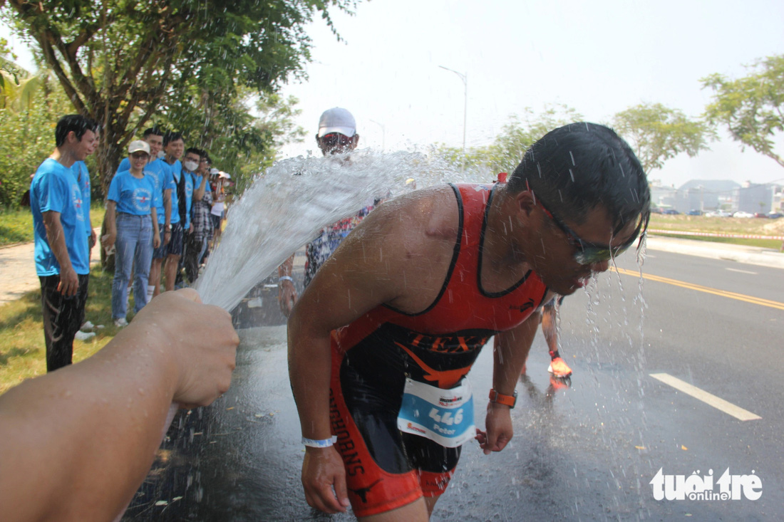 Volunteers spray water to cool down a triathlete at the 2024 VinFast Ironman 70.3 Vietnam in Da Nang City, central Vietnam, May 10, 2024. Photo: Truong Trung / Tuoi Tre