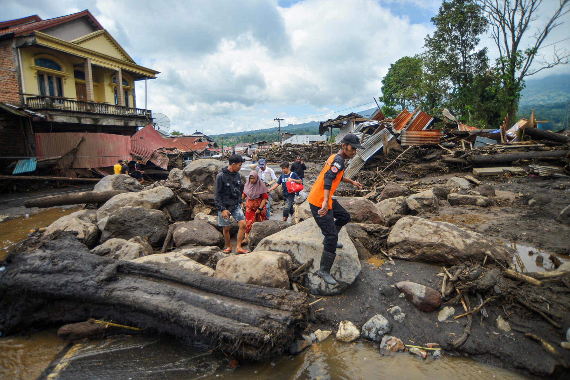 Locals walk in an area affected by heavy rain brought flash floods and landslides as they are evacuated in Agam, West Sumatra province, Indonesia, May 12, 2024.