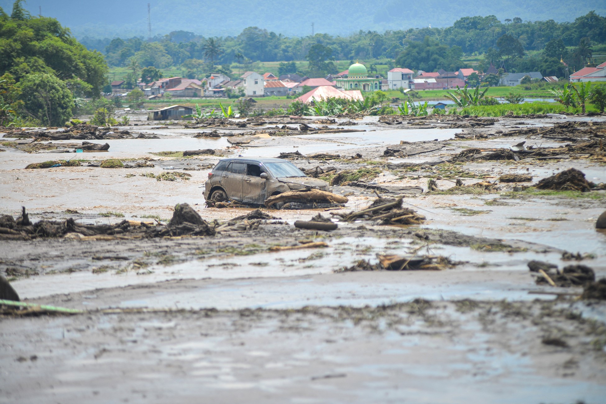 A damaged car is seen in an area area affected by heavy rain brought flash floods and landslides in Agam, West Sumatra province, Indonesia, May 12, 2024.
