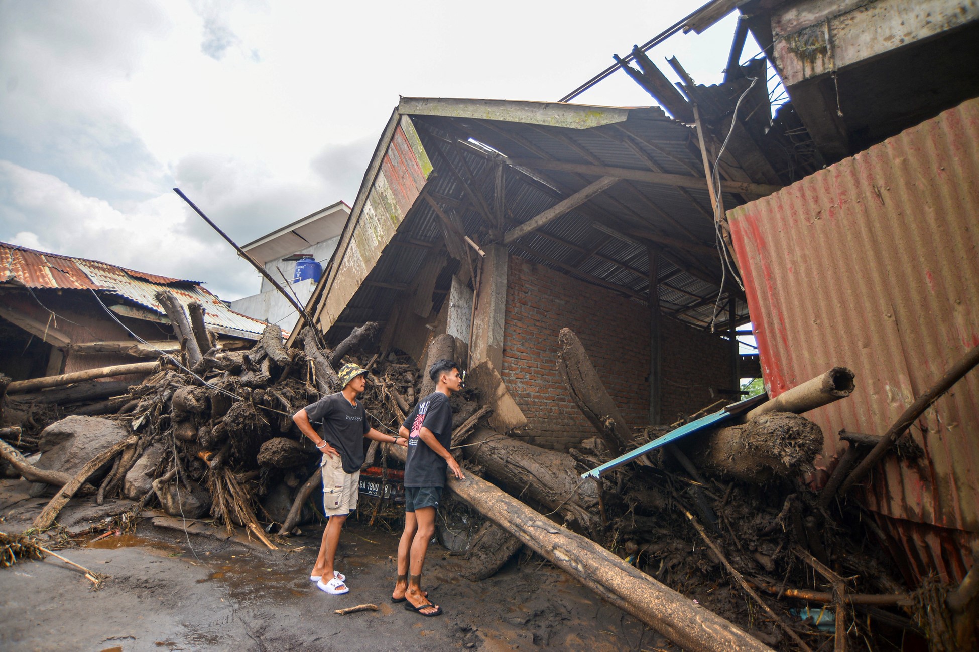People look at damaged houses affected by heavy rain brought flash floods and landslides in Agam, West Sumatra province, Indonesia, Indonesia, May 12, 2024.