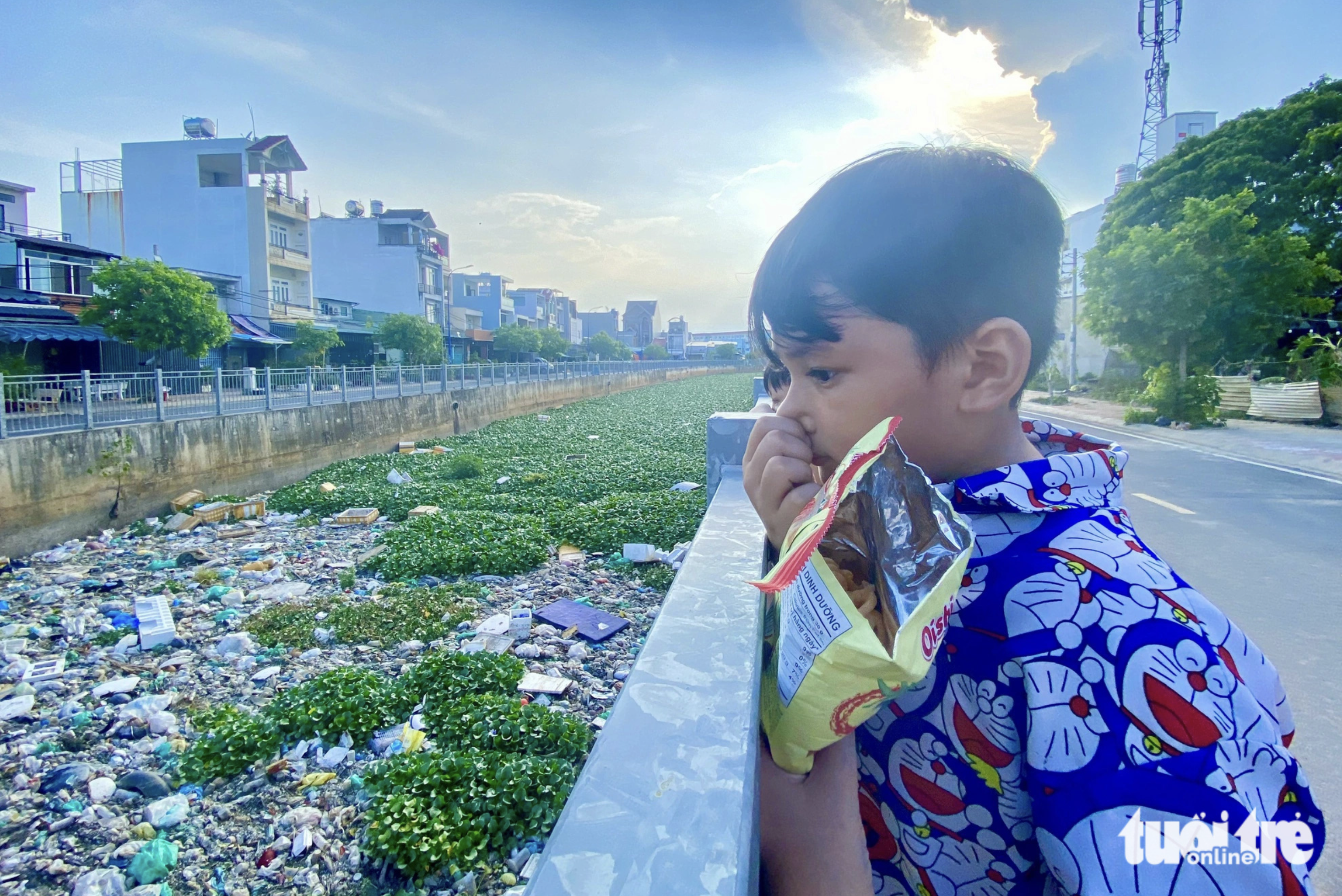 A boy covers his nose due to the smelly odor from the polluted Nuoc Den Canal in Binh Tan District under Ho Chi Minh City. Photo: Tien Quoc / Tuoi Tre