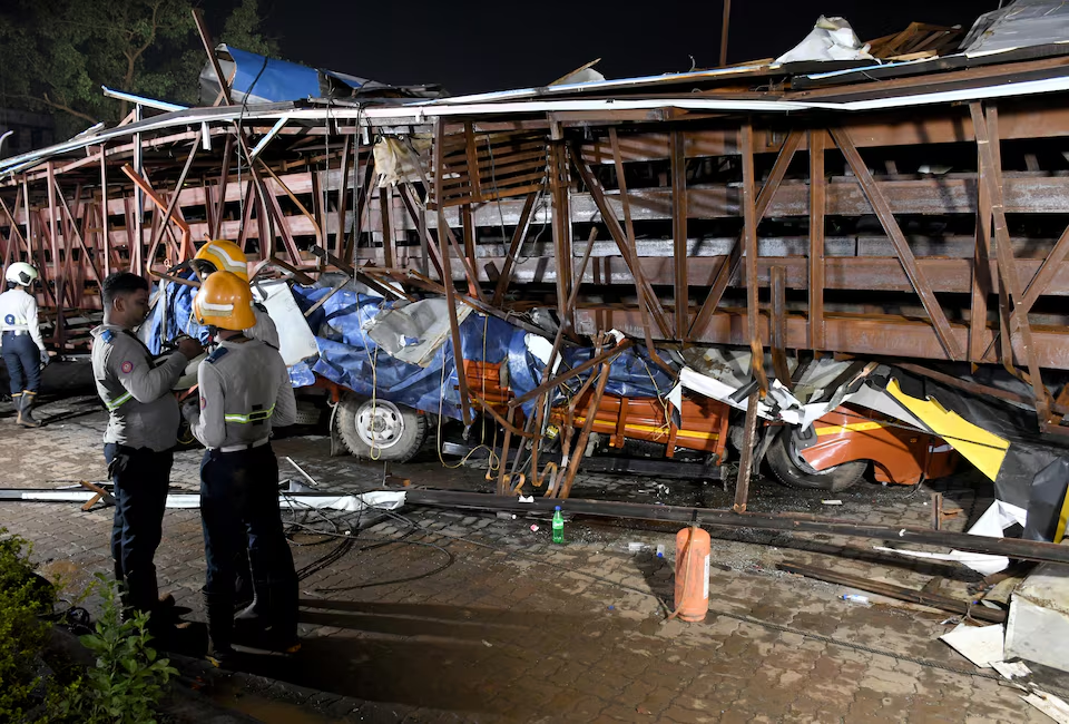 Firefighters stand next to the damaged vehicles trapped in the debris after a massive billboard fell during a rainstorm in Mumbai, India, May 13, 2024. Photo: Reuters