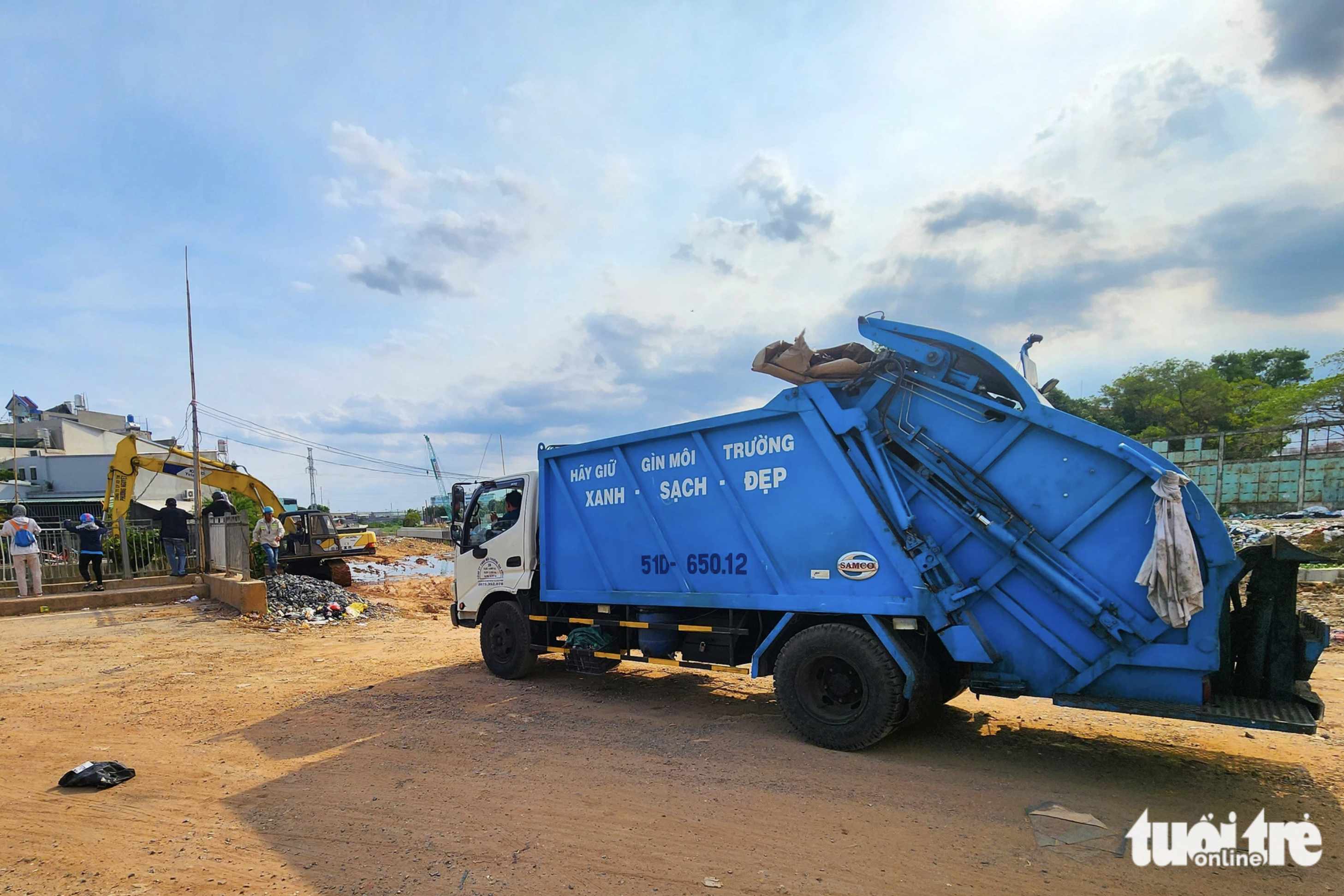 Garbage trucks and excavators are mobilized to Nuoc Den Canal in Binh Hung Hoa Ward in Binh Tan District, Ho Chi Minh City for the cleanup operation on May 13, 2024. Photo: Ngoc Khai / Tuoi Tre
